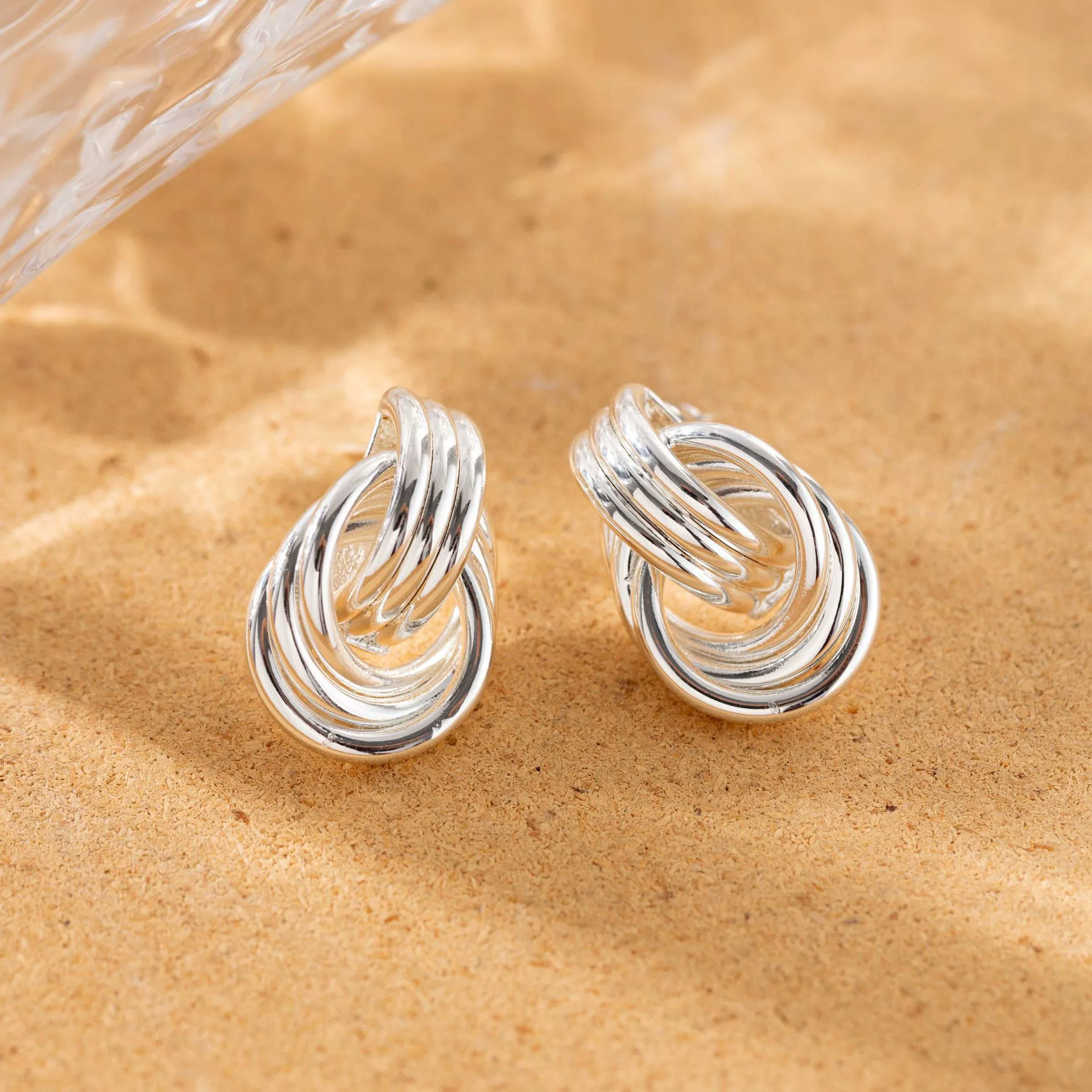 livke-silver-triple-coil-hoop-earrings.jpg LIVKE’s silver geometric hoop earrings with triple coil layers, styled with a sleek bun for minimalist office elegance.