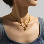 LIVKE’s oval tiger eye necklace with 18K gold-plated chain, styled with black sweater for minimalist elegance.