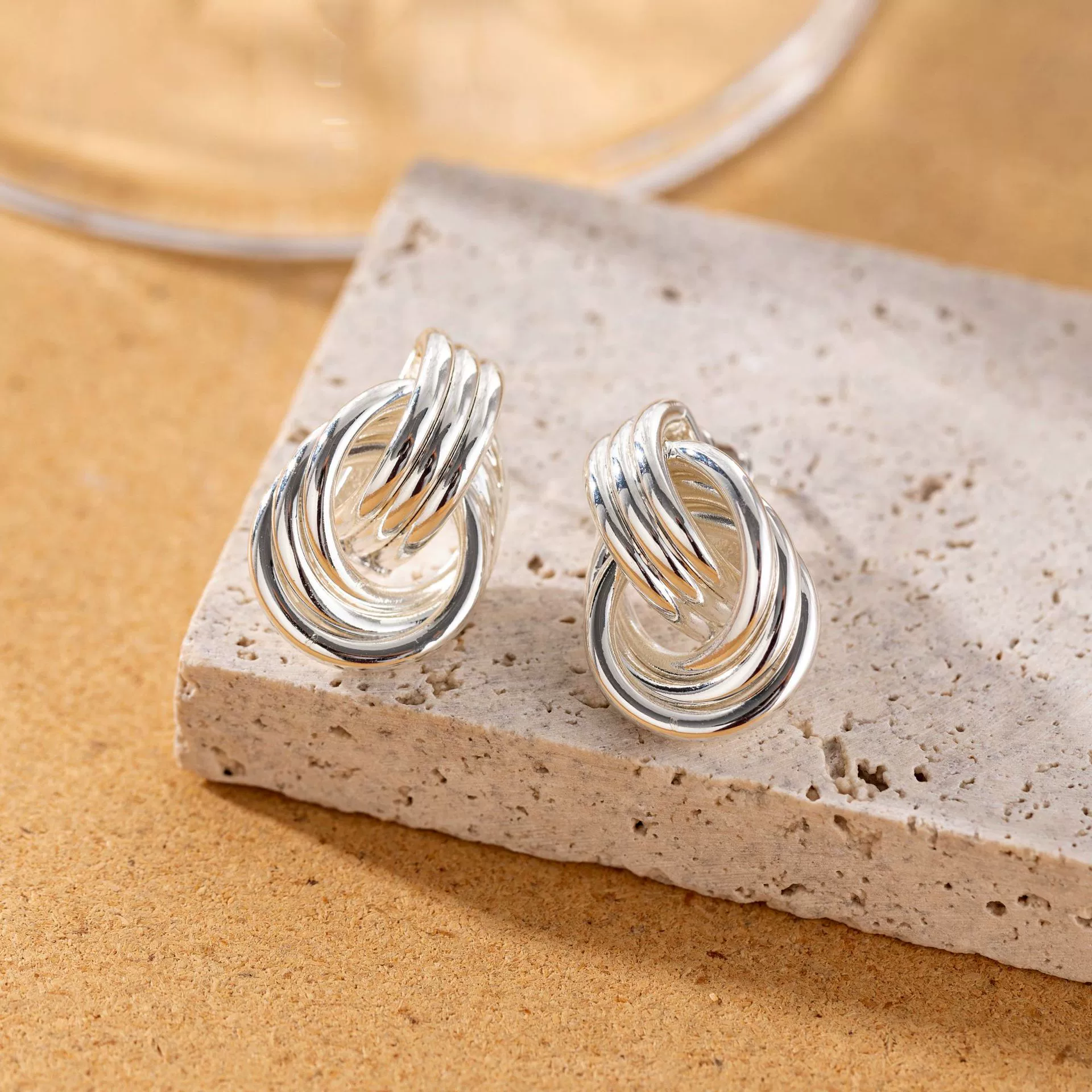 livke-silver-triple-coil-hoop-earrings.jpg LIVKE’s silver geometric hoop earrings with triple coil layers, styled with a sleek bun for minimalist office elegance.