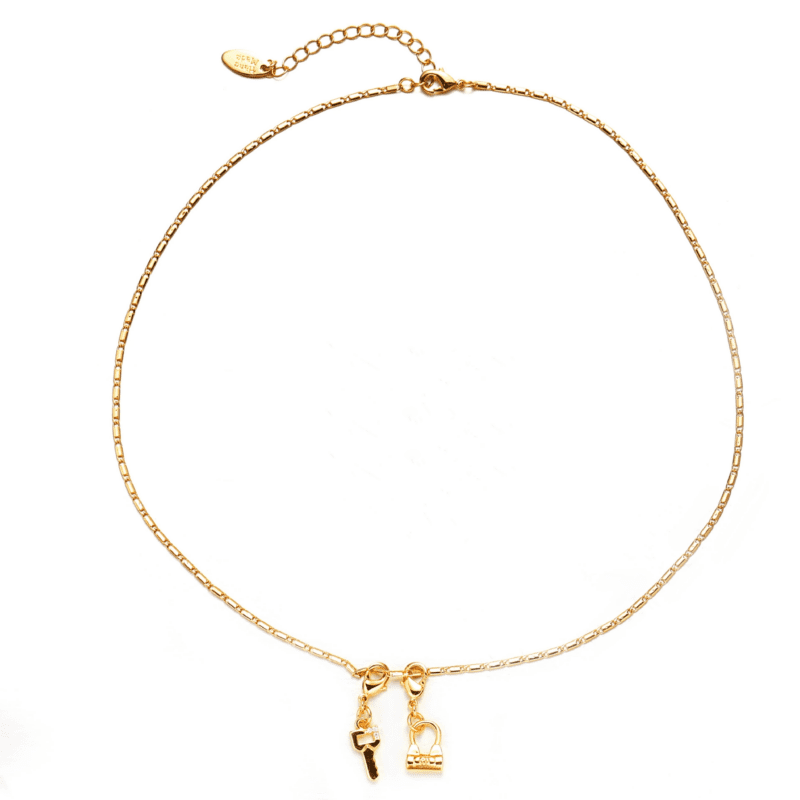 Close-up of LIVKE’s electroplated 18K gold brass zircon stone necklace with a round lock clasp, styled over a chic neckline.