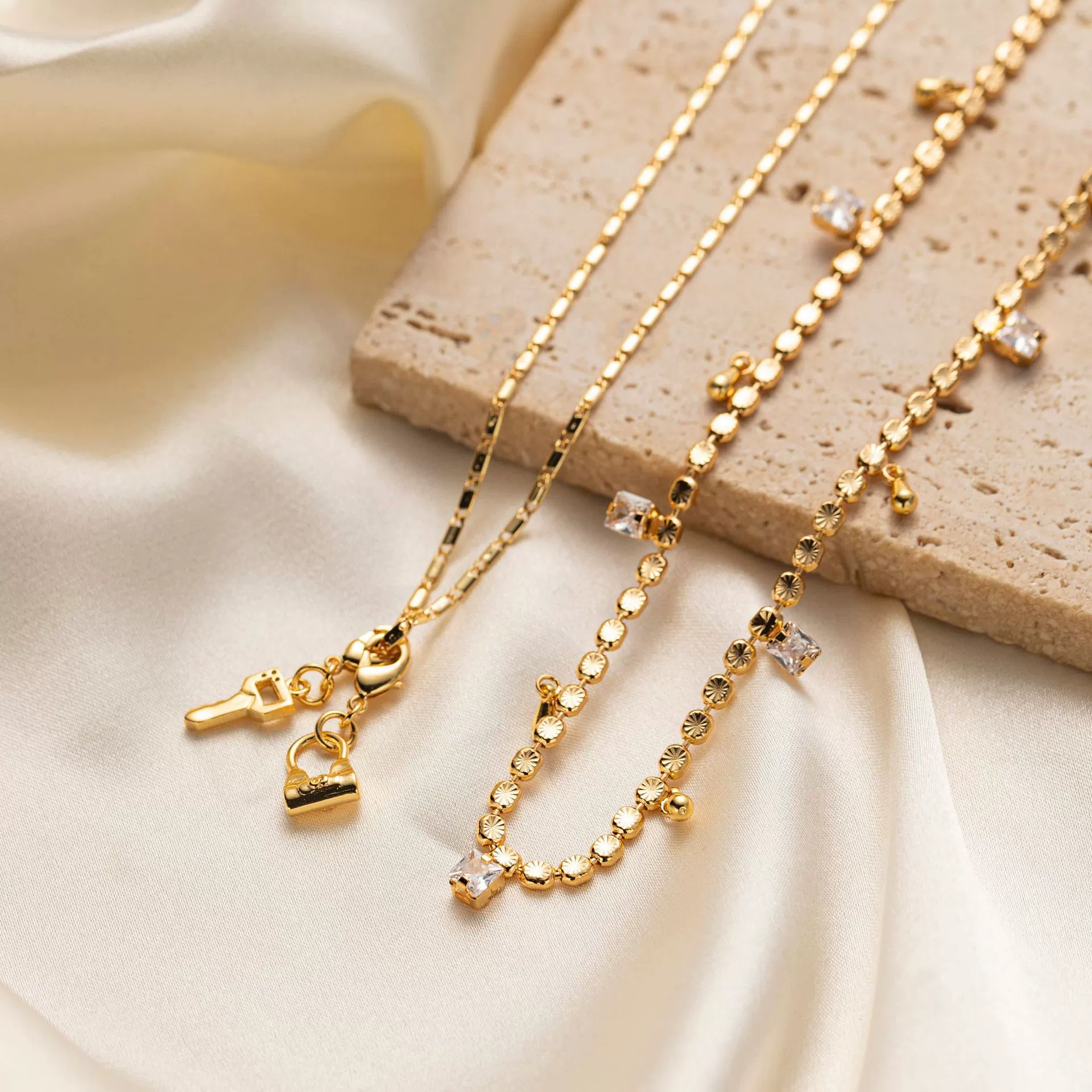 Close-up of LIVKE’s electroplated 18K gold brass zircon stone necklace with a round lock clasp, styled over a chic neckline.