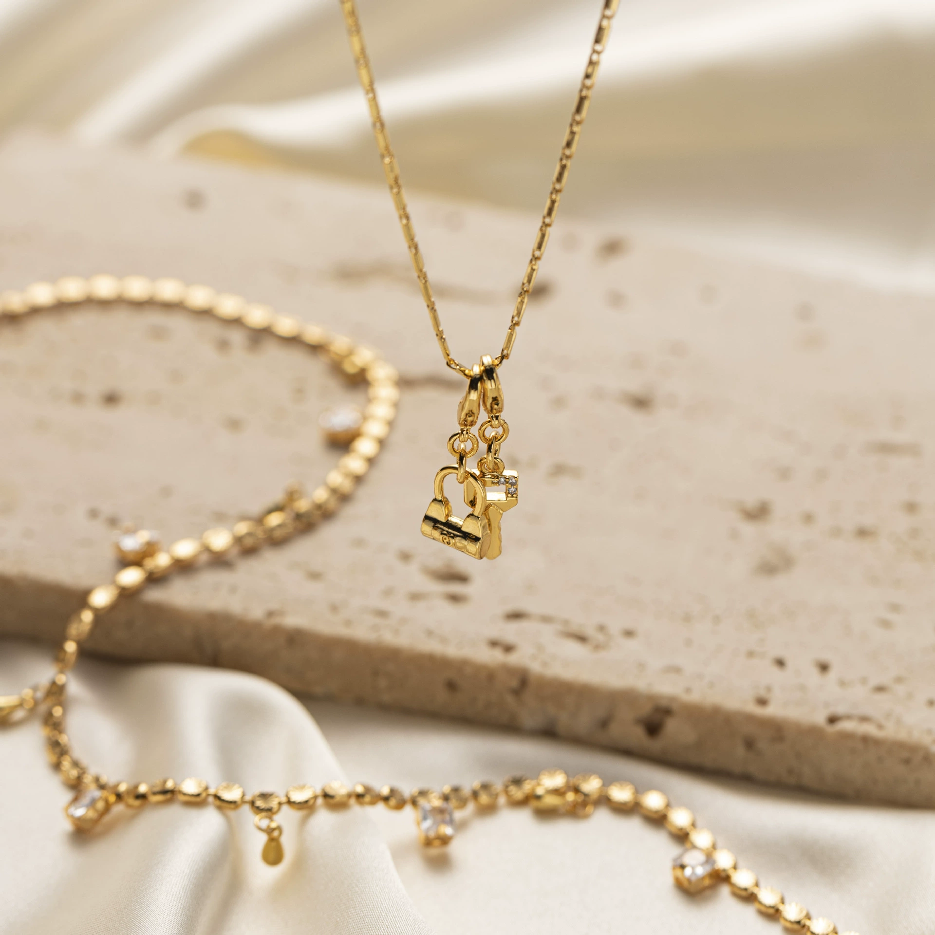 Close-up of LIVKE’s electroplated 18K gold brass zircon stone necklace with a round lock clasp, styled over a chic neckline.