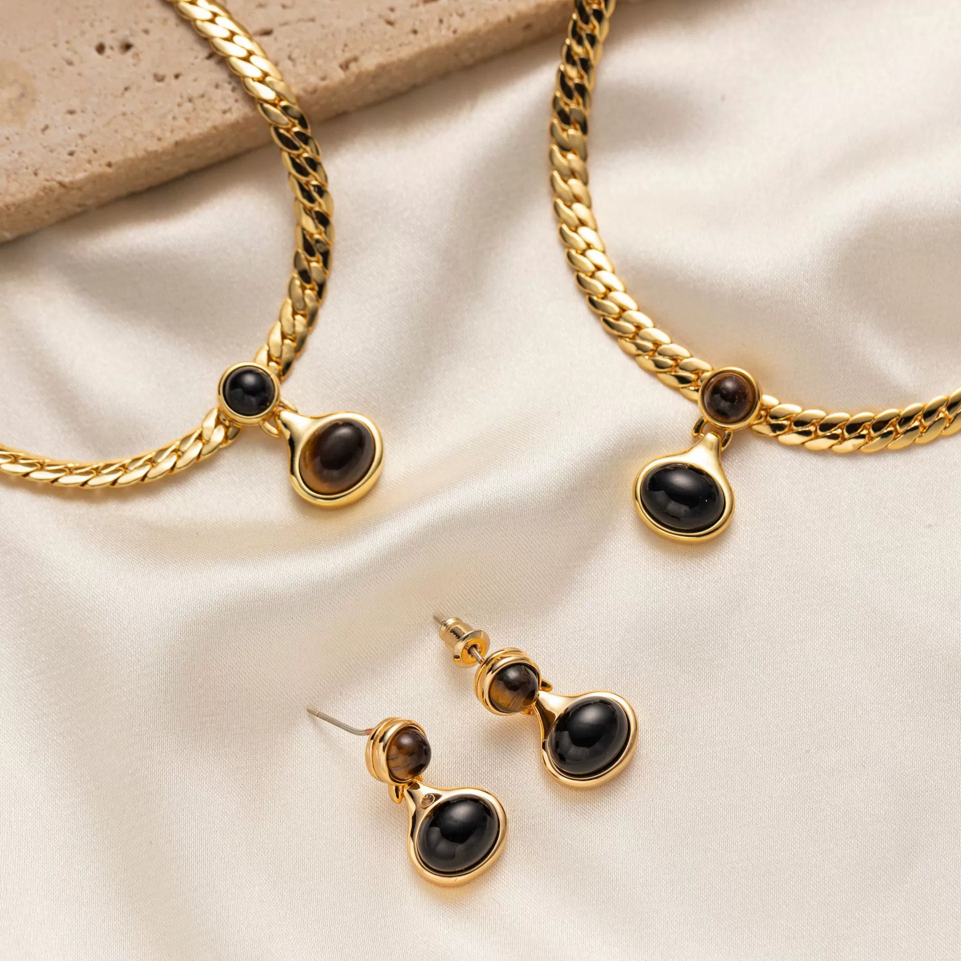 livke-18k-gold-tiger-eye-snake-chain-necklace.jpg (3) LIVKE’s gold tiger eye oval pendant on a snake chain, styled with a linen dress for boho-chic everyday elegance.