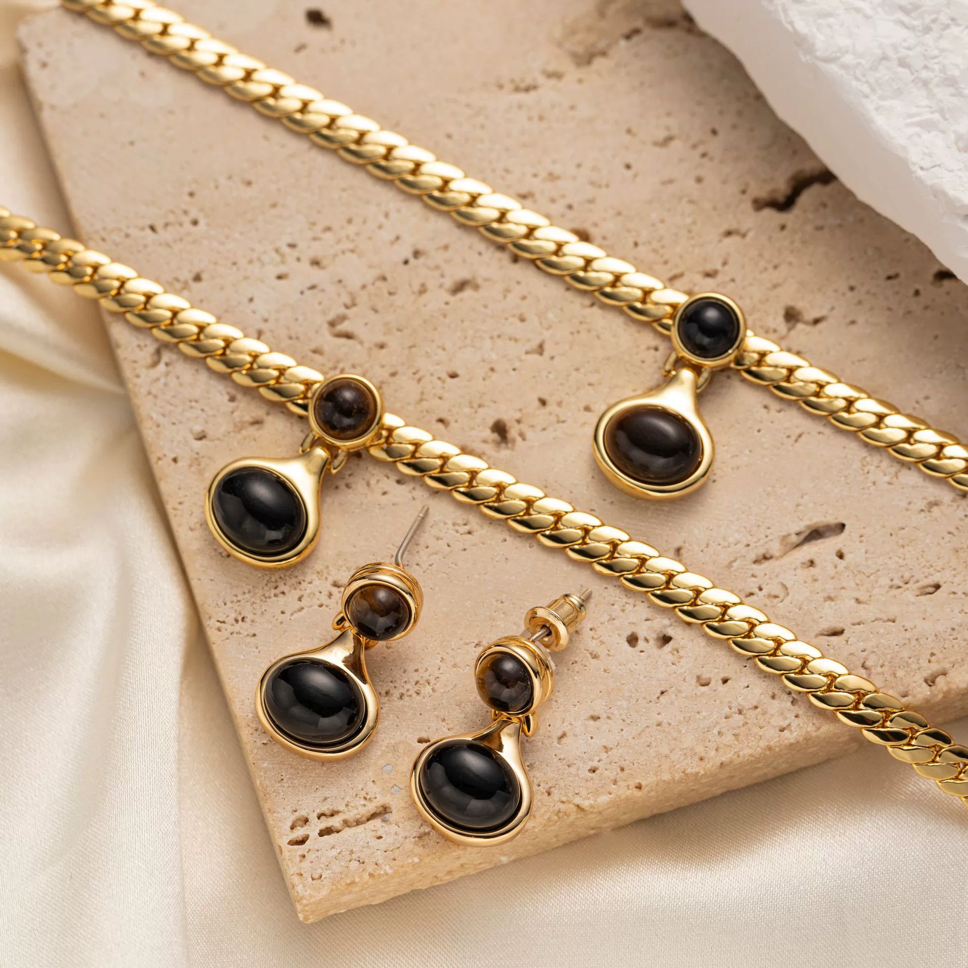 livke-18k-gold-tiger-eye-snake-chain-necklace.jpg LIVKE’s gold tiger eye oval pendant on a snake chain, styled with a linen dress for boho-chic everyday elegance.