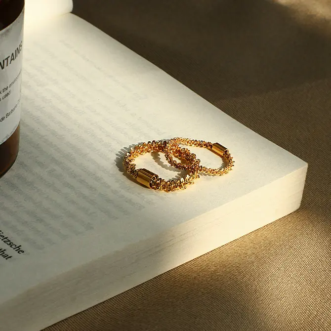 LIVKE’s 18K PVD gold minimalist ring stacked with raw-edge bands for modern gender-neutral style.