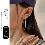 LIVKE’s minimalist sterling silver hoop earrings styled with a white button-up for office-ready elegance.