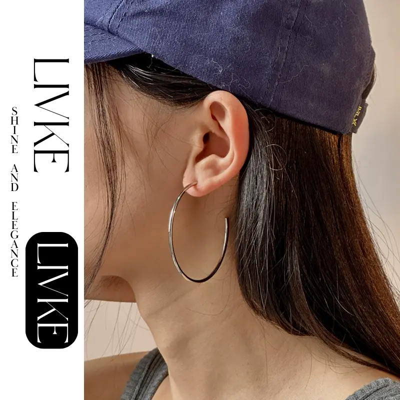 LIVKE’s minimalist sterling silver hoop earrings styled with a white button-up for office-ready elegance.