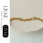 LIVKE’s gold watch band bracelet with geometric zirconia links, styled with a leather folio for modern power dressing.