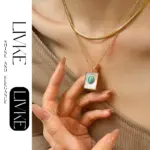 LIVKE’s gold snake chain necklace with shell and turquoise pendant, layered with beaded bracelets for boho summer style.