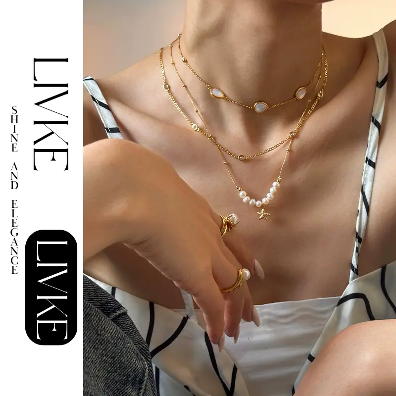 LIVKE’s layered pearl and shell necklaces styled with a white sundress and straw bag for beach-to-bar elegance.