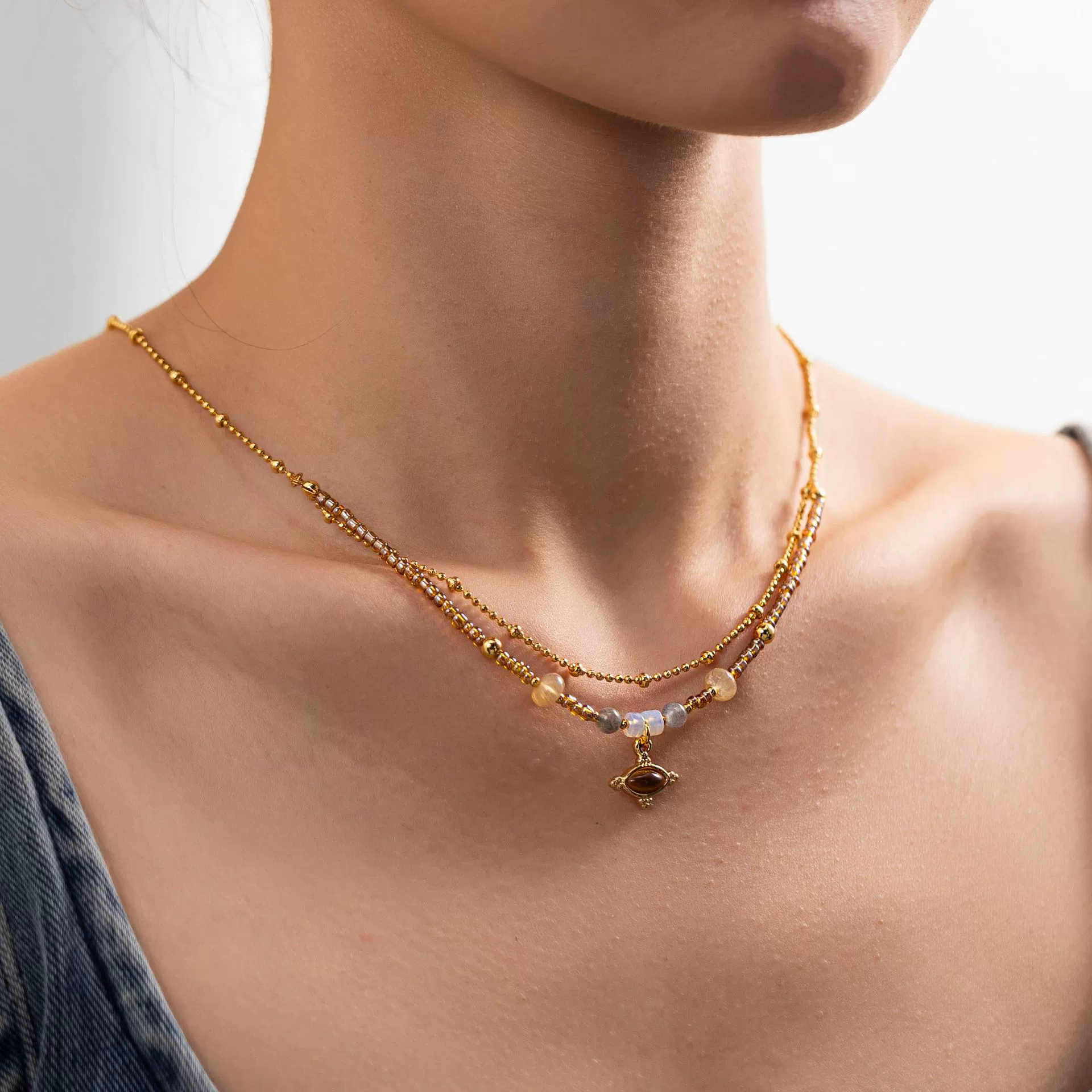 livke-tiger-eye-bead-gold-necklace (3) LIVKE’s tiger eye bead necklace with gold and zirconia accents, styled with a linen dress for boho everyday elegance.