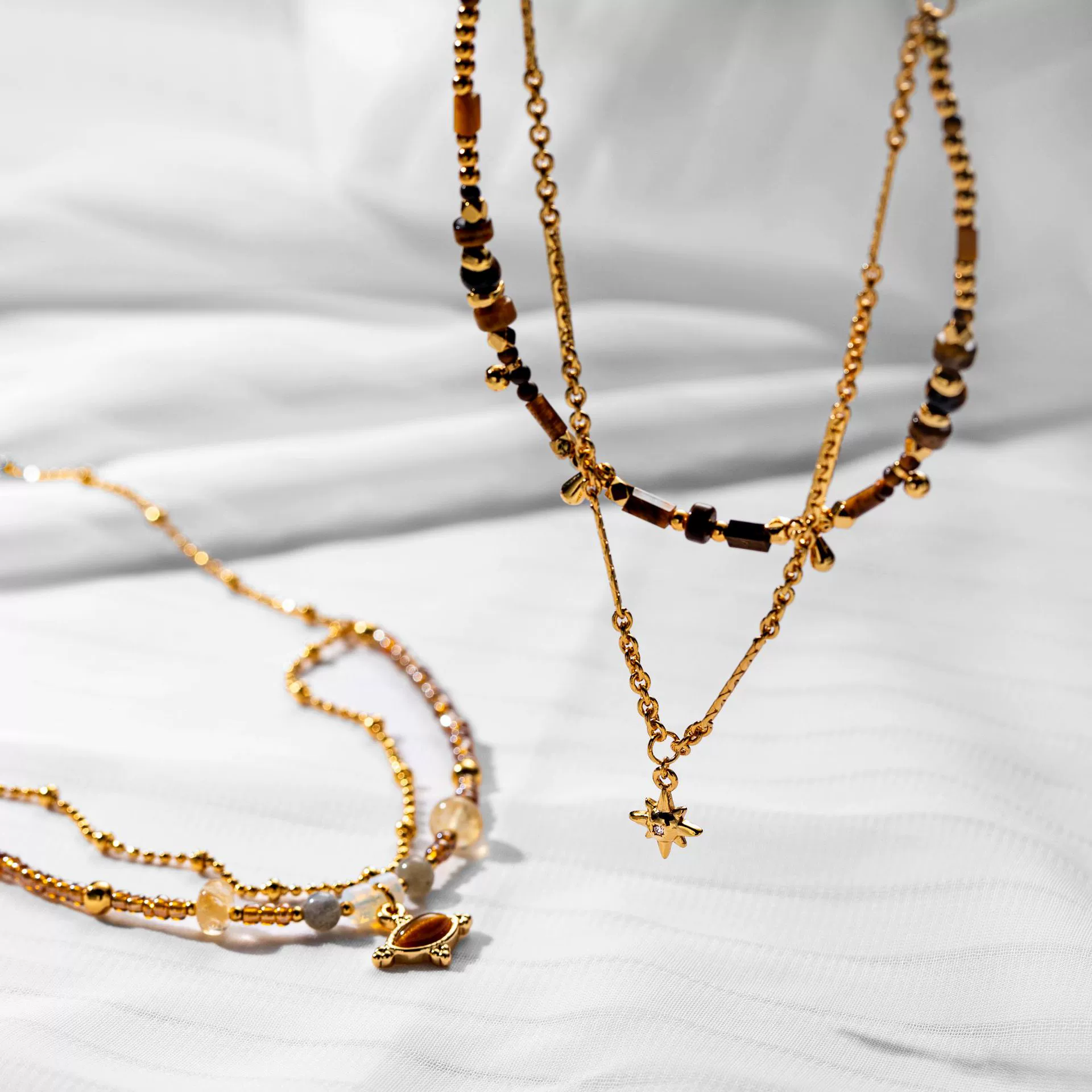 livke-tiger-eye-bead-gold-necklace (4) LIVKE’s tiger eye bead necklace with gold and zirconia accents, styled with a linen dress for boho everyday elegance.