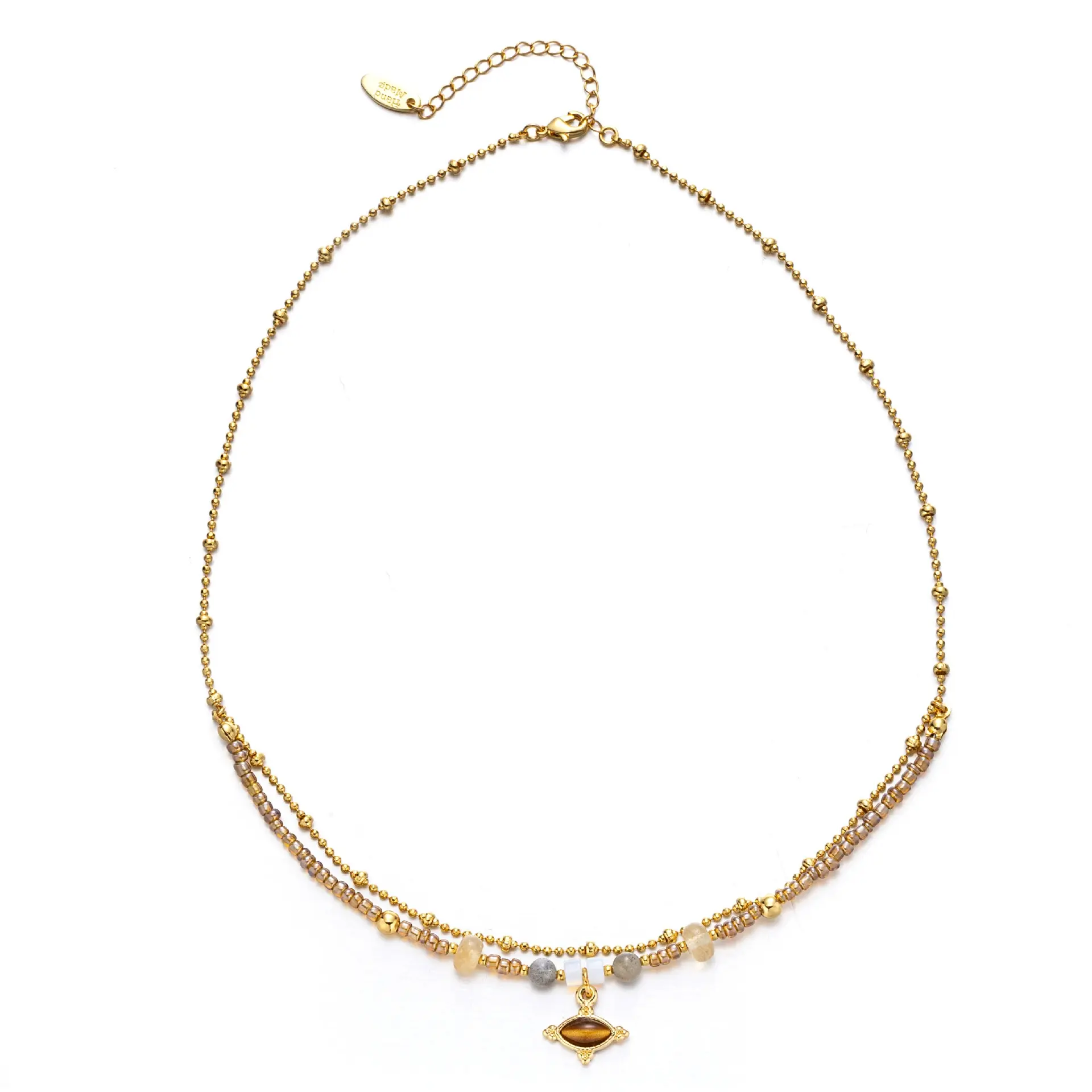 livke-tiger-eye-bead-gold-necklace LIVKE’s tiger eye bead necklace with gold and zirconia accents, styled with a linen dress for boho everyday elegance.