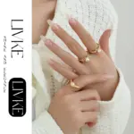 LIVKE’s gold leaf and pearl adjustable ring on a hand with neutral nails, styled with a linen dress for effortless boho elegance.