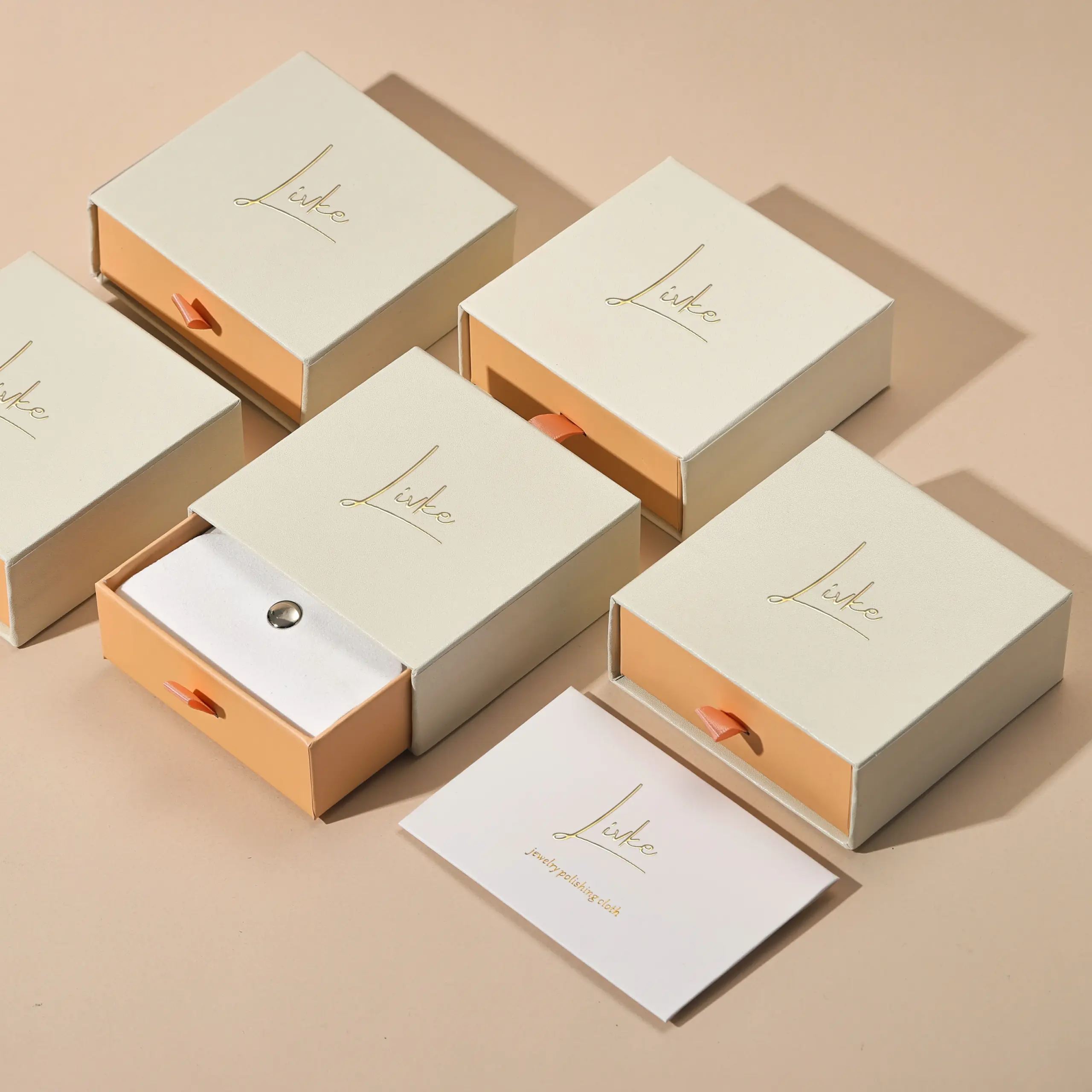 gold-foil-jewelry-care-set-flatlay (2) Beige drawer box open with polishing cloth, necklace and ring on velvet background