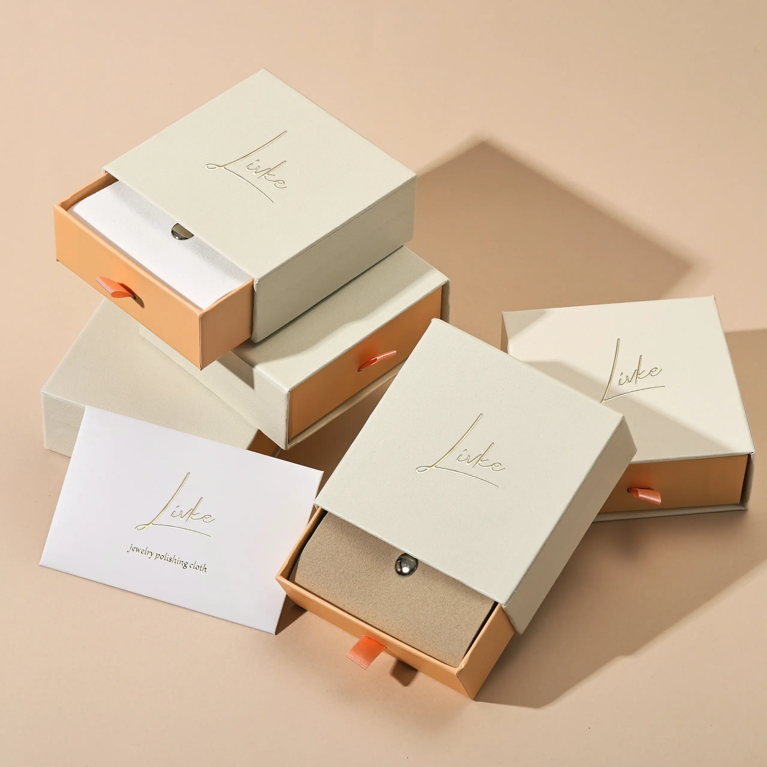 gold-foil-jewelry-care-set-flatlay (3) Beige drawer box open with polishing cloth, necklace and ring on velvet background