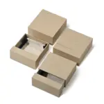 Beige drawer box open with polishing cloth, necklace and ring on velvet background