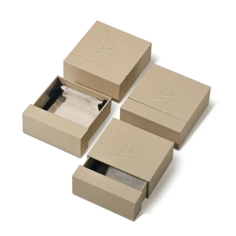 Beige drawer box open with polishing cloth, necklace and ring on velvet background