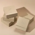 Beige drawer box open with polishing cloth, necklace and ring on velvet background