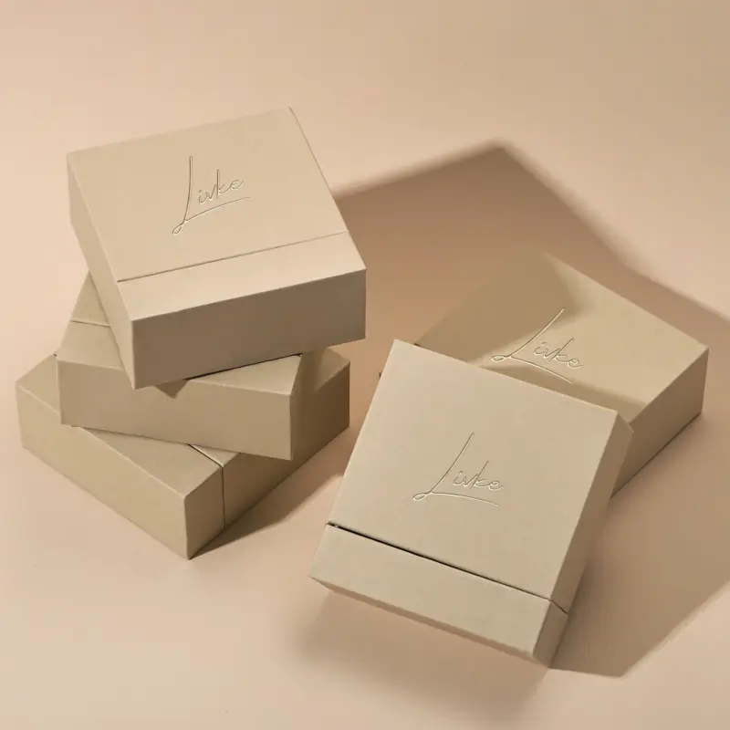 Beige drawer box open with polishing cloth, necklace and ring on velvet background