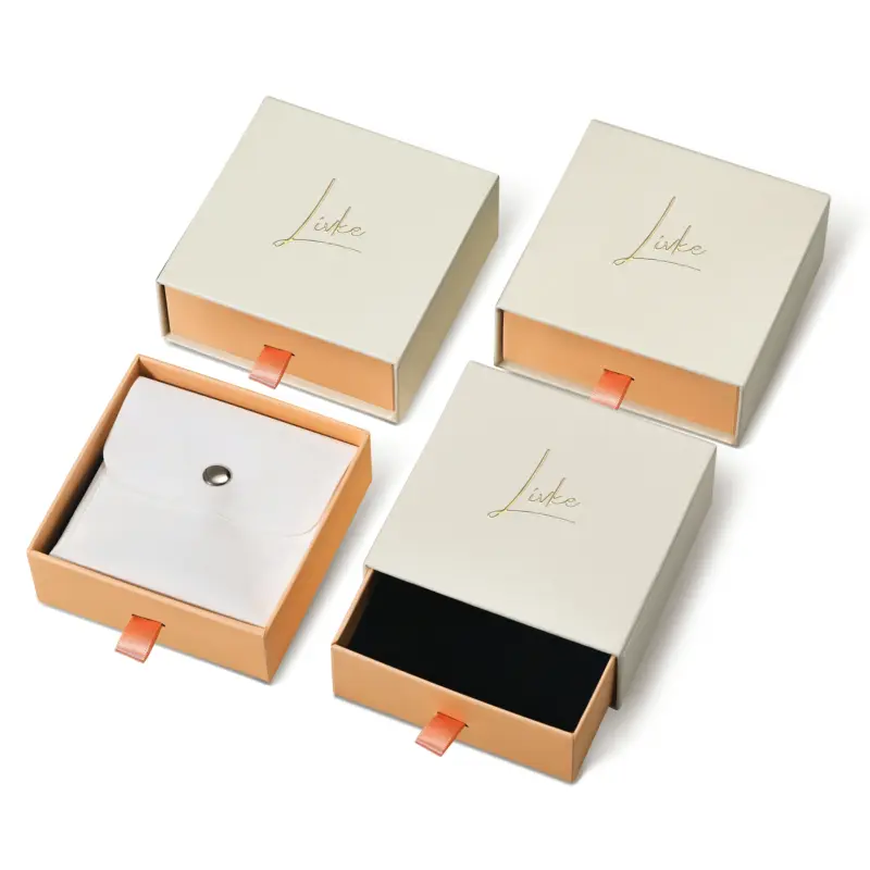 Beige drawer box open with polishing cloth, necklace and ring on velvet background