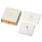 Beige drawer box open with polishing cloth, necklace and ring on velvet background