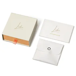 Beige drawer box open with polishing cloth, necklace and ring on velvet background
