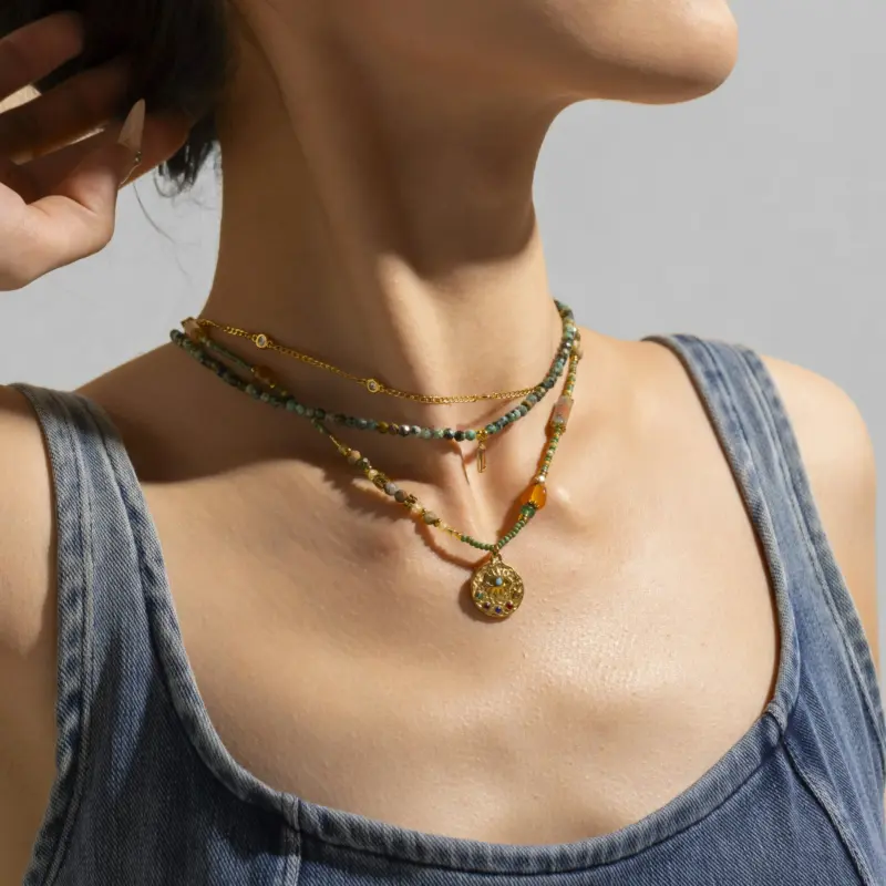 Adjustable LIVKE brass necklace with amethyst and turquoise beads layered over linen dress for bohemian everyday style.
