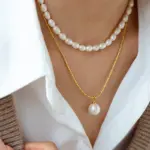 Woman wearing LIVKE braided gold chain pearl necklace with tailored blouse, showcasing minimalist office jewelry
