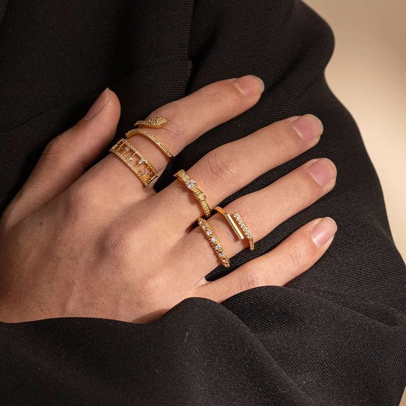 Eclectic woman stacking LIVKE gold textured rings on fingers while browsing vintage market, showcasing bohemian jewelry styling