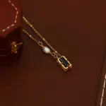 Midnight Pearl Necklace 5 Model wearing LIVKE necklace with black CZ and pearl pendants on collarbone