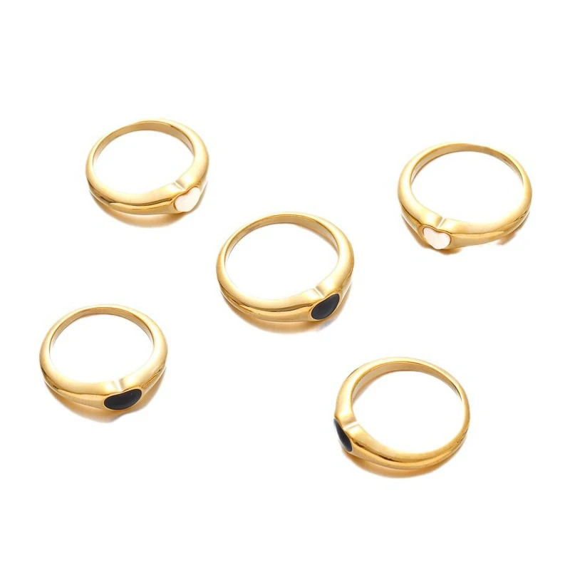 Hand wearing LIVKE contrast heart ring with black and white enamel, paired with both tailored suit and casual denim