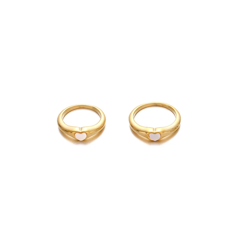 Hand wearing LIVKE contrast heart ring with black and white enamel, paired with both tailored suit and casual denim