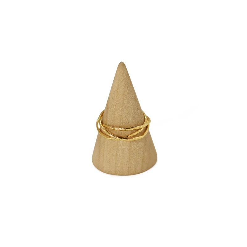 Three layered brass rings with spiral/chain/wave designs in 18K gold plating, stacked on a wooden tray for boho style