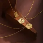 Celestial Charm Necklace Set 5 Gold sun and moon pendants layered on model with white linen shirt