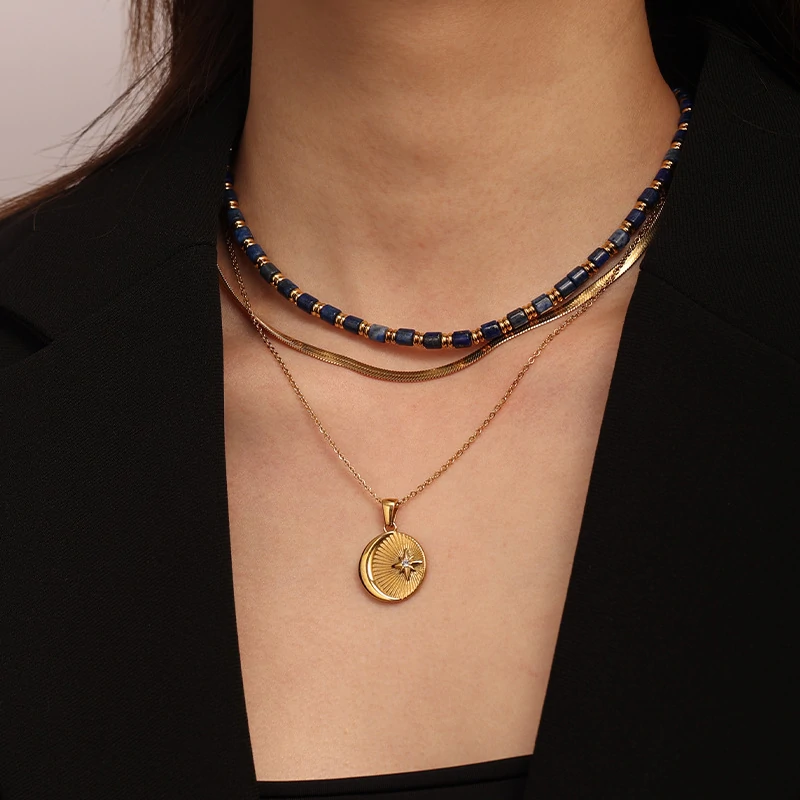 livke-celestial-sun-moon-stack (4) Gold sun and moon pendants layered on model with white linen shirt