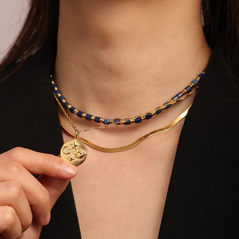 livke-celestial-sun-moon-stack (5) Gold sun and moon pendants layered on model with white linen shirt