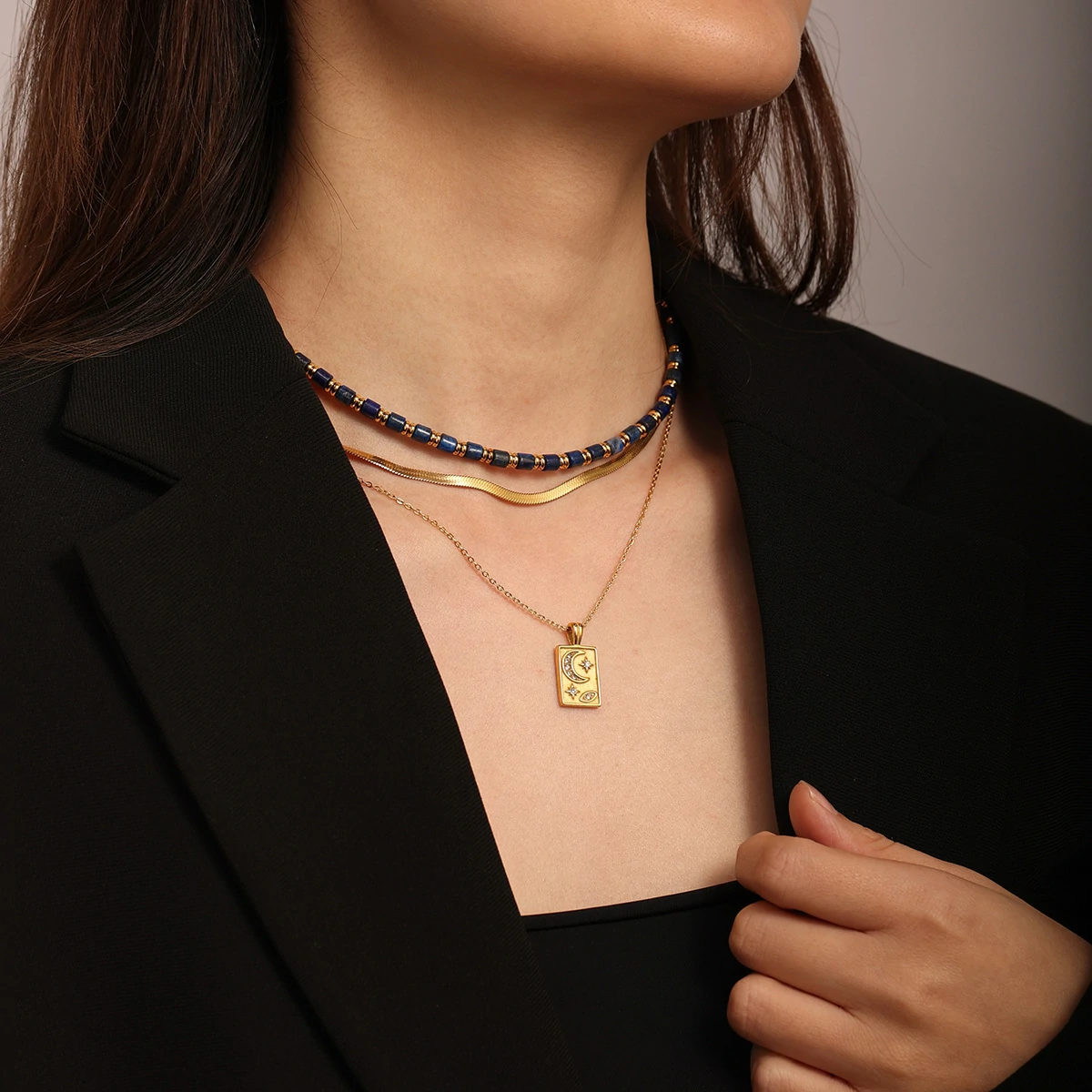 livke-celestial-sun-moon-stack (6) Gold sun and moon pendants layered on model with white linen shirt