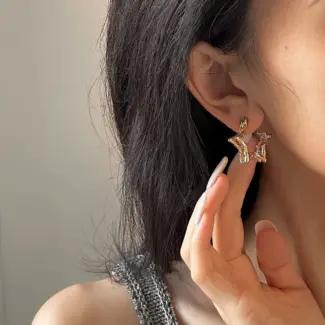 Model wearing LIVKE gold and silver star earrings with cyberpunk makeup, showcasing urban rebel jewelry style