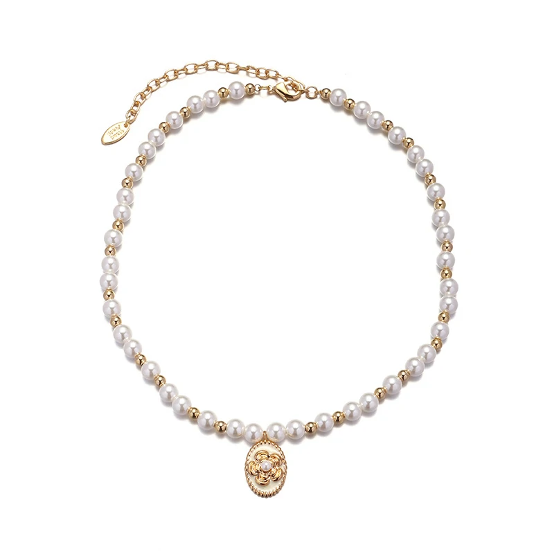 livke-gold-pearl-brass-necklace-vintage-layering Woman wearing LIVKE gold plated pearl necklace with silk blouse and tailored blazer, showcasing vintage-inspired office to evening jewelry