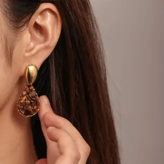 Woman wearing LIVKE teardrop tiger eye earrings with tailored blazer, showcasing minimalist office jewelry with natural stone accents