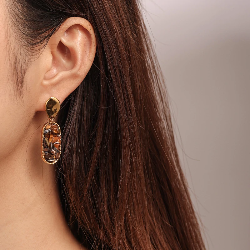 Woman wearing LIVKE teardrop tiger eye earrings with tailored blazer, showcasing minimalist office jewelry with natural stone accents