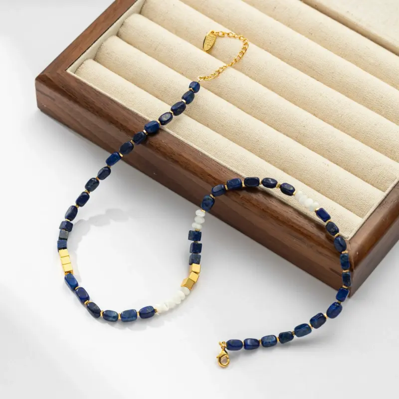 Woman wearing LIVKE lapis lazuli and gold beaded necklace with tailored black dress, showcasing mysterious yet elegant office-to-event jewelry