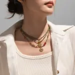 Woman wearing LIVKE cubic zirconia sweater necklace with knitwear and blazer, showcasing versatile minimalist jewelry for work and casual outfits