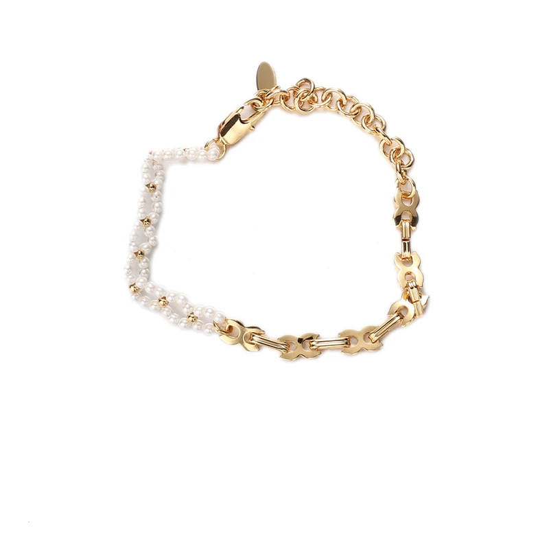 Stylist mixing LIVKE gold chain modules with baroque pearls on antique velvet tray in Paris concept store