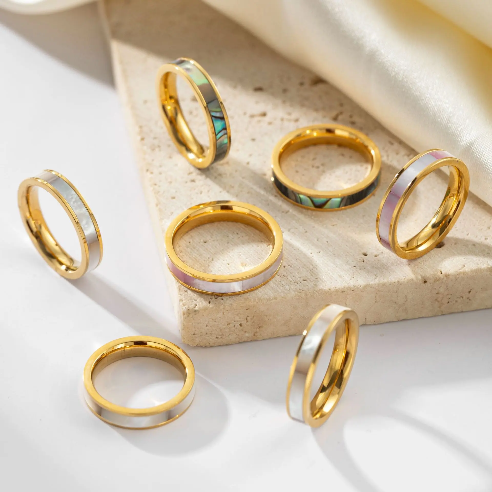 livke-mother-of-pearl-ring-tri-color-stack (3) LIVKE 18K gold-plated mother-of-pearl rings in three colors (white/pink/grey) stacked on finger with minimalist outfits