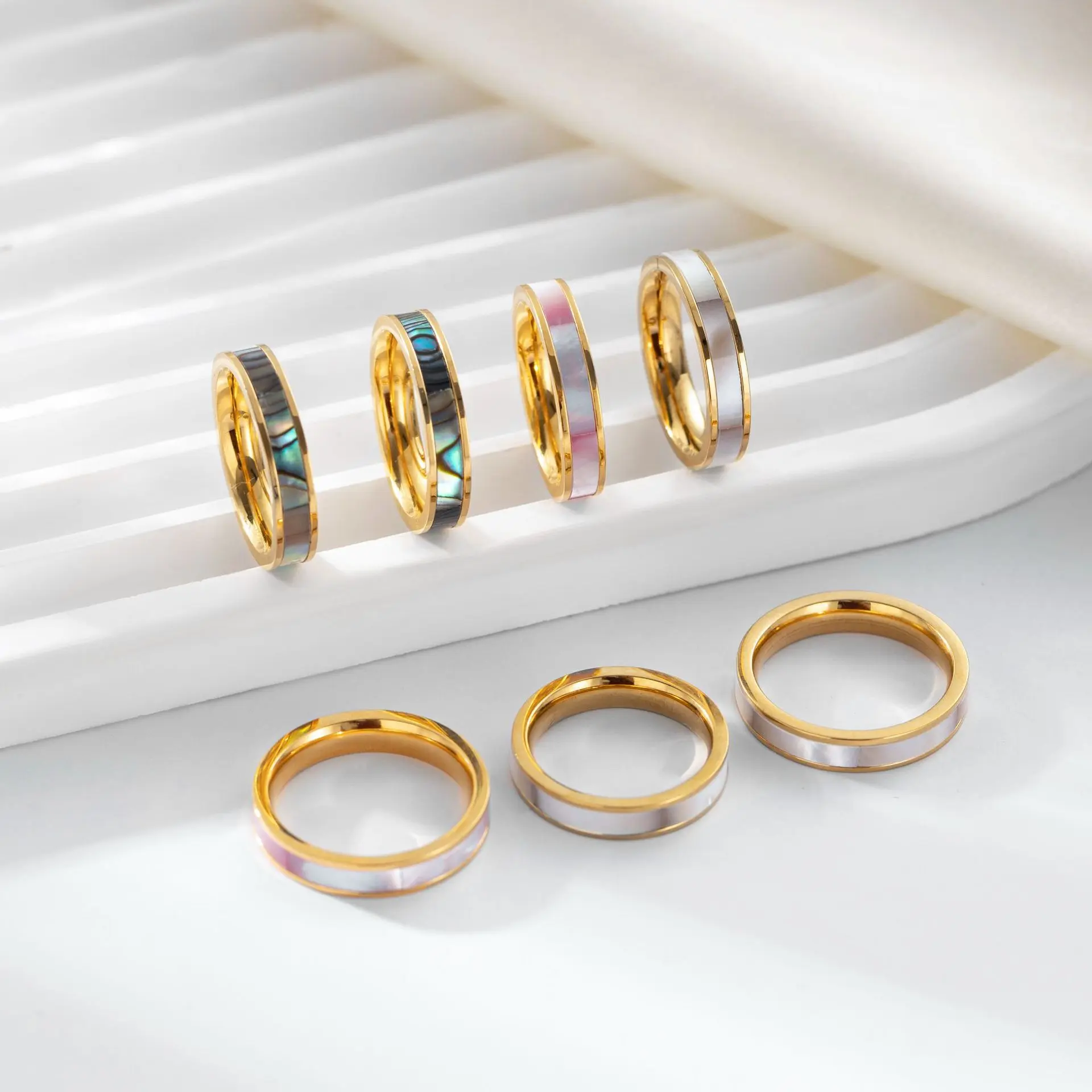 livke-mother-of-pearl-ring-tri-color-stack (4) LIVKE 18K gold-plated mother-of-pearl rings in three colors (white/pink/grey) stacked on finger with minimalist outfits