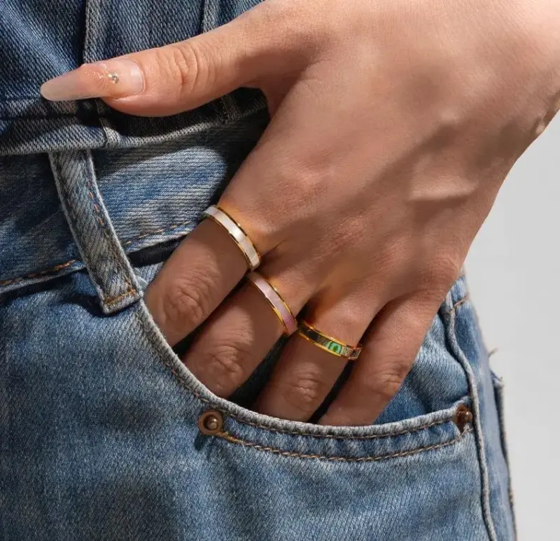LIVKE 18K gold-plated mother-of-pearl rings in three colors (white/pink/grey) stacked on finger with minimalist outfits
