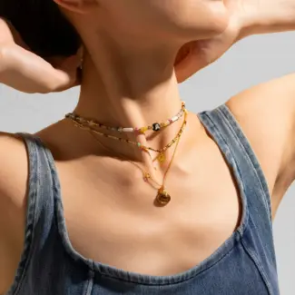 Woman wearing LIVKE multi-color stone necklace at desert festival, showcasing boho jewelry with adjustable gold pendant