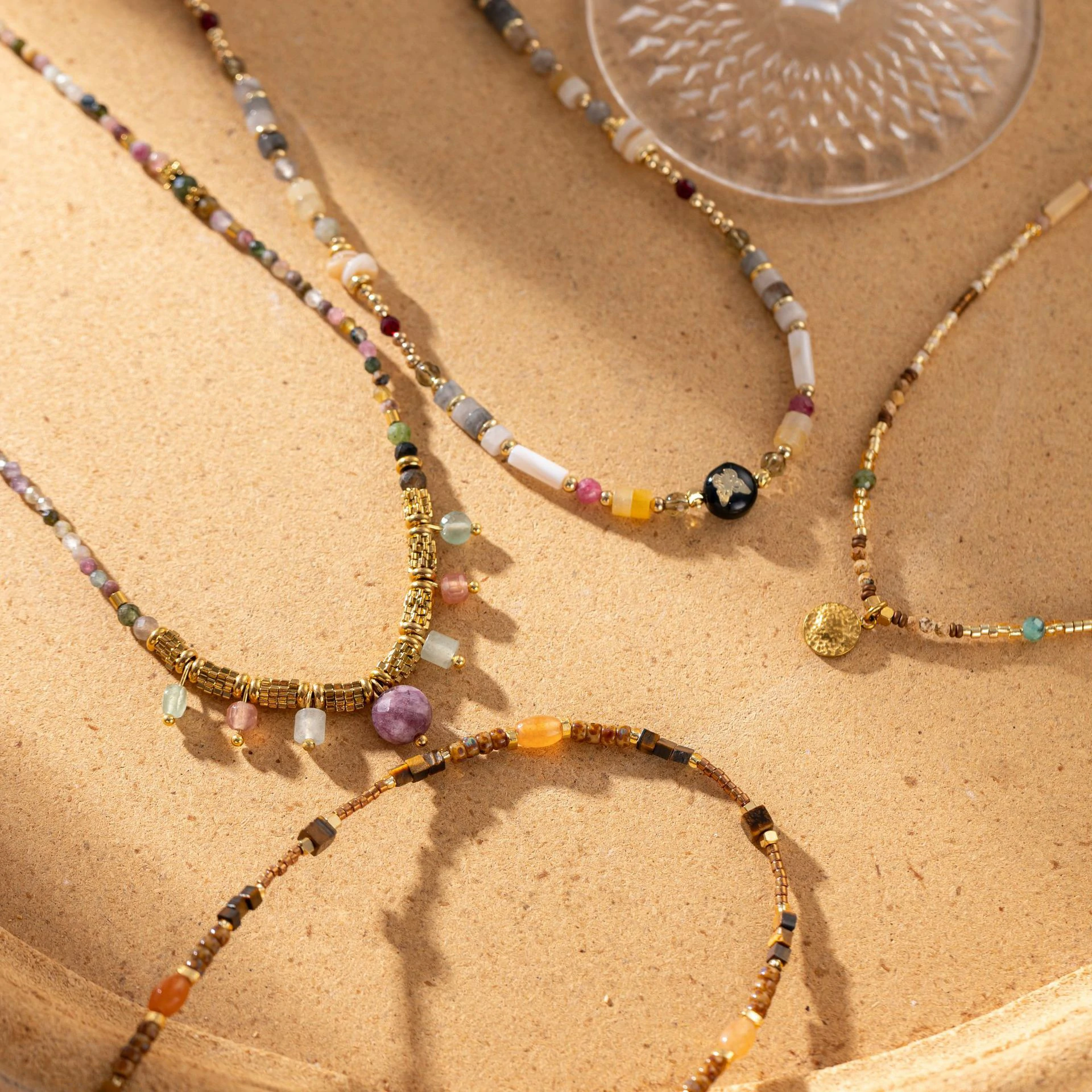 Woman wearing LIVKE multi-color stone necklace at desert festival, showcasing boho jewelry with adjustable gold pendant